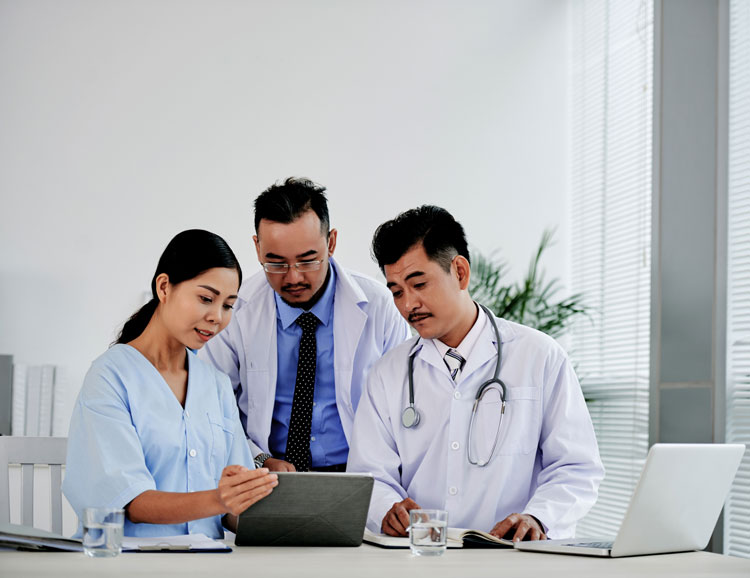 Utilization management team, looking over data on a tablet